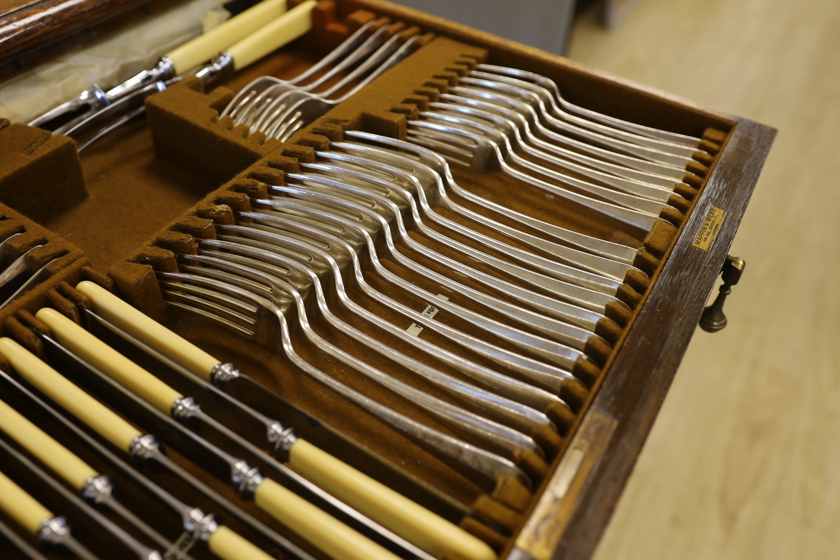 An oak standing canteen with two drawers of Mappin and Webb silver plated cutlery, settings for twelve people, 78cm high x 70cm wide x 54cm deep